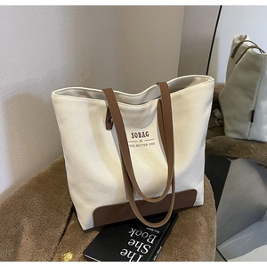Detail view of cream canvas tote bag with brown straps and Sobag brand logo text