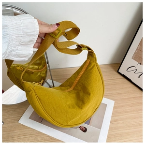 Close-up of yellow nylon crescent moon bag featuring natural texture and zip closure