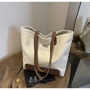 Detail of canvas tote bag with brown leather handles and SOBAG lettering logo