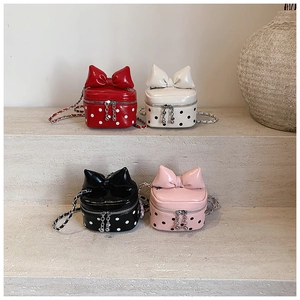 Detailed macro view of four mini polka dot crossbody bags with 3D bow accents and metal chains