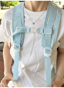 Close-up of the light blue adjustable chest strap with white buckle on a backpack