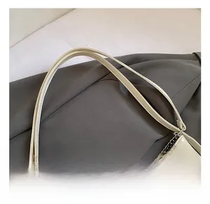 Detailed close-up of cream oil wax leather tote bag with silver chain and handle stitching