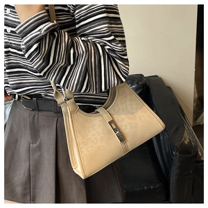 Detail of beige faux animal texture underarm bag with silver rectangular metal buckle