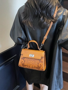 Retro orange-brown leather handbag with floral embossing and silver twist lock detail