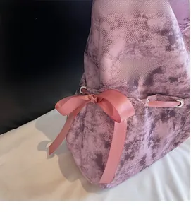 Détail d'un sac cabas tie-dye rose avec un nœud décoratif en satin et œillets
