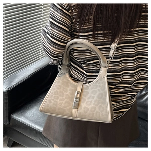 Detail of grey leopard print hobo bag showing silver metal buckle and detachable strap