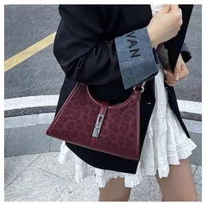 Detail of vintage burgundy leopard print bucket bag with silver metal piston buckle