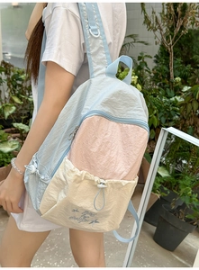 Macro detail of patchwork nylon backpack with pastel colors and star embroidery