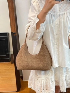 Brown woven hobo bag with minimalist curved design for casual summer commuting