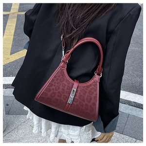 Detail of burgundy leopard print bucket bag with silver metal buckle and leather trim