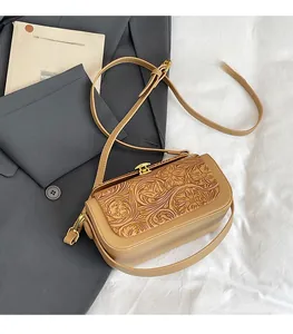 Close-up of vintage brown faux leather crossbody bag with embossed floral texture details