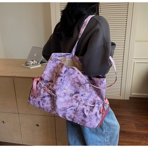 Vue de dos d'un grand cabas en toile tie-dye violette avec des nœuds roses sur modèle