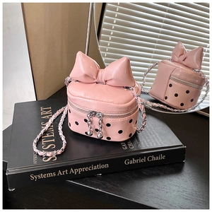Detailed macro view showing pink polka dot pattern and elegant bow decoration on mini bag