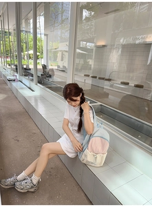 Outdoor shot of a color-block backpack with drawstring pockets and nylon fabric finish
