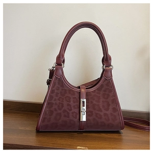 Detail view of burgundy leopard print bucket bag with vintage silver metal piston clasp