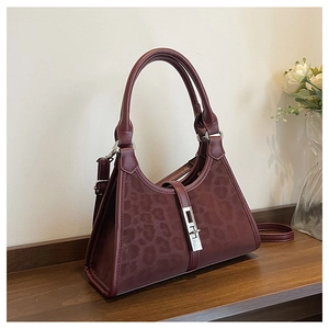 Close-up of leopard pattern texture on burgundy leather bucket bag with metallic buckle