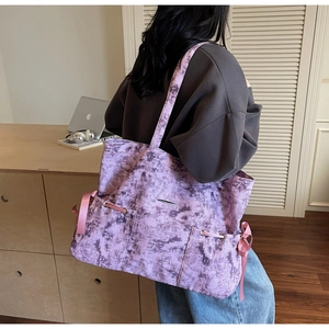 Détail du sac cabas tie-dye violet avec poches avant et cordons de serrage en ruban rose
