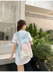 Outdoor lifestyle shot of woman wearing a tricolor nylon backpack with drawstring pocket
