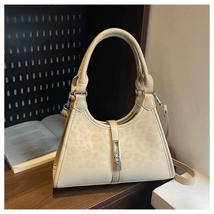 Detail shot of a cream bucket bag with leopard print, silver buckle and leather texture