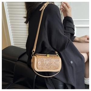 Detail of floral embossed leather on a light brown vintage box bag with gold lock