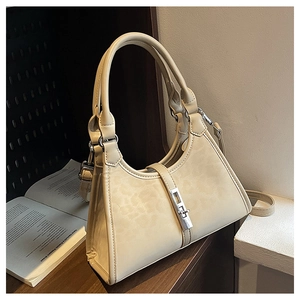 Detail of off-white bucket bag featuring a silver metal buckle and textured faux leather