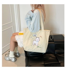 Detail der cremefarbenen Canvas-Tasche mit Schaf-Stickerei und Kordelzugverschluss