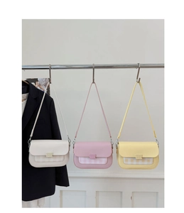 Gros plan de trois sacs à rabat couleurs macaron en blanc crème, rose clair et jaune