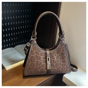 Detail shot of leopard print bucket bag with silver buckle and leather handle