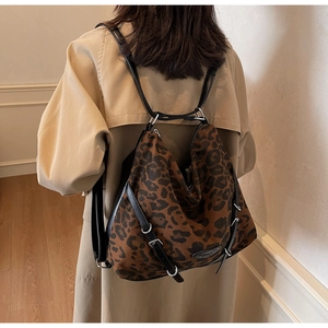 Detail of leopard print canvas bag with black leather trim and silver metal hardware