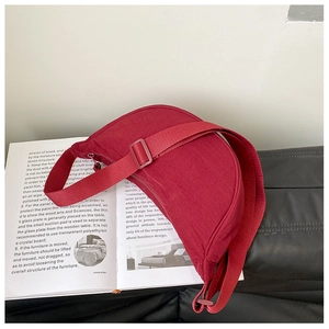 Detail of red nylon crescent bag on a magazine with an adjustable shoulder strap