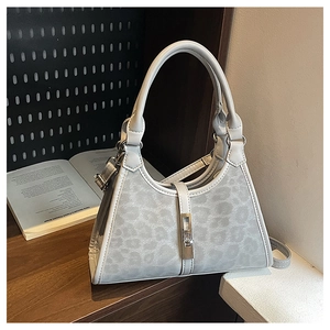Macro shot of light gray leopard print bucket bag with metal buckle and top handle