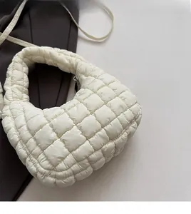 Detail shot of the white quilted fabric and silver zipper of this large padded bag