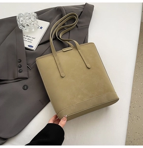 Detail of olive green suede tote bag with slim shoulder straps for professional look