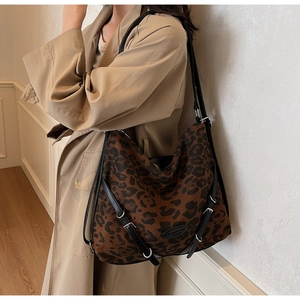 Detail of leopard print tote bag with adjustable black strap on a beige trench coat