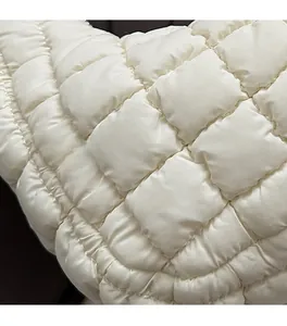 Detailed macro shot of high-quality ivory white quilted fabric with precise stitching details