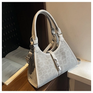 Detail of light gray bucket bag with animal print side and silver metal twist lock