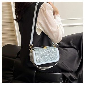 Detail view of the elegant grey-blue crossbody bag featuring floral embossed textures