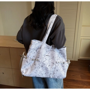 Vue détaillée du grand sac cabas motif marbre avec cordons de serrage latéraux