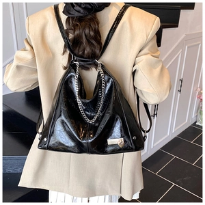 Close-up of black glossy oil wax leather hobo bag with silver chain and heart metal lock