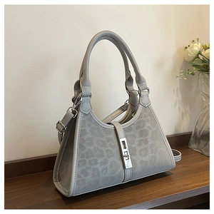 Close-up of grey leopard pattern bucket bag with silver square metal lock and double handles