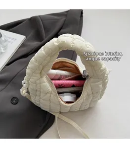 Top-down view of a spacious white quilted cloud bag holding daily cosmetics and a wallet