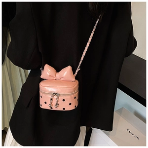 Detailed view of pink polka dot mini bag featuring a large bow and silver chain strap