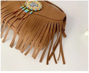 Détail du sac en daim marron avec franges bohémiennes et médaillon en perles colorées