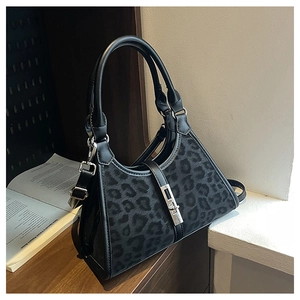 Close-up of leopard print bucket bag with black leather handle and silver metal clasp