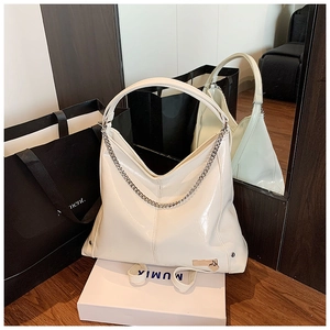 Detail of off-white PU leather hobo bag featuring silver chain and heart charm detail