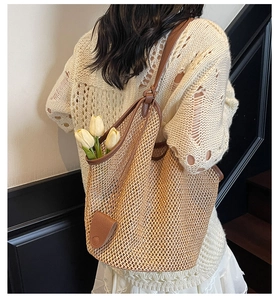 Detail of French straw tote bag with brown leather trim and thin shoulder straps