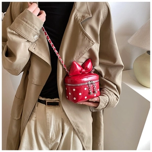 Detailed view of red polka dot mini bag with oversized bow on a crossbody chain strap