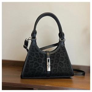 Detail of black bucket bag featuring leopard print texture and silver metal lock
