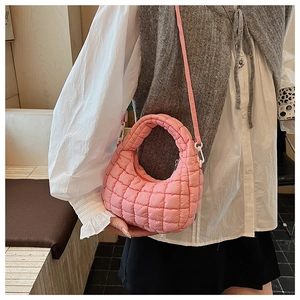 Pink quilted crossbody puff bag shown on model for a stylish modern streetwear look