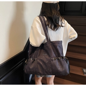 Détail du grand sac cabas montrant le tissu marbré et le cordon de serrage latéral